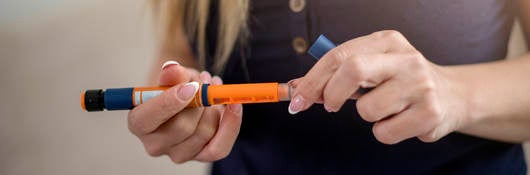 woman holding insulin injector pen